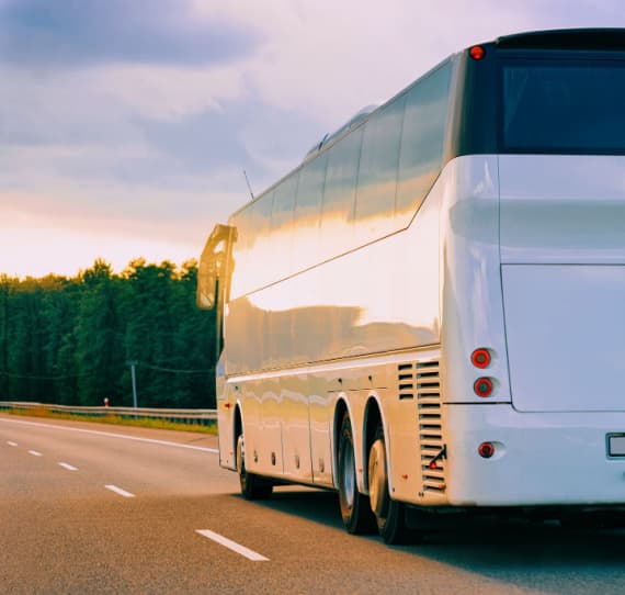 a white charter bus on a road